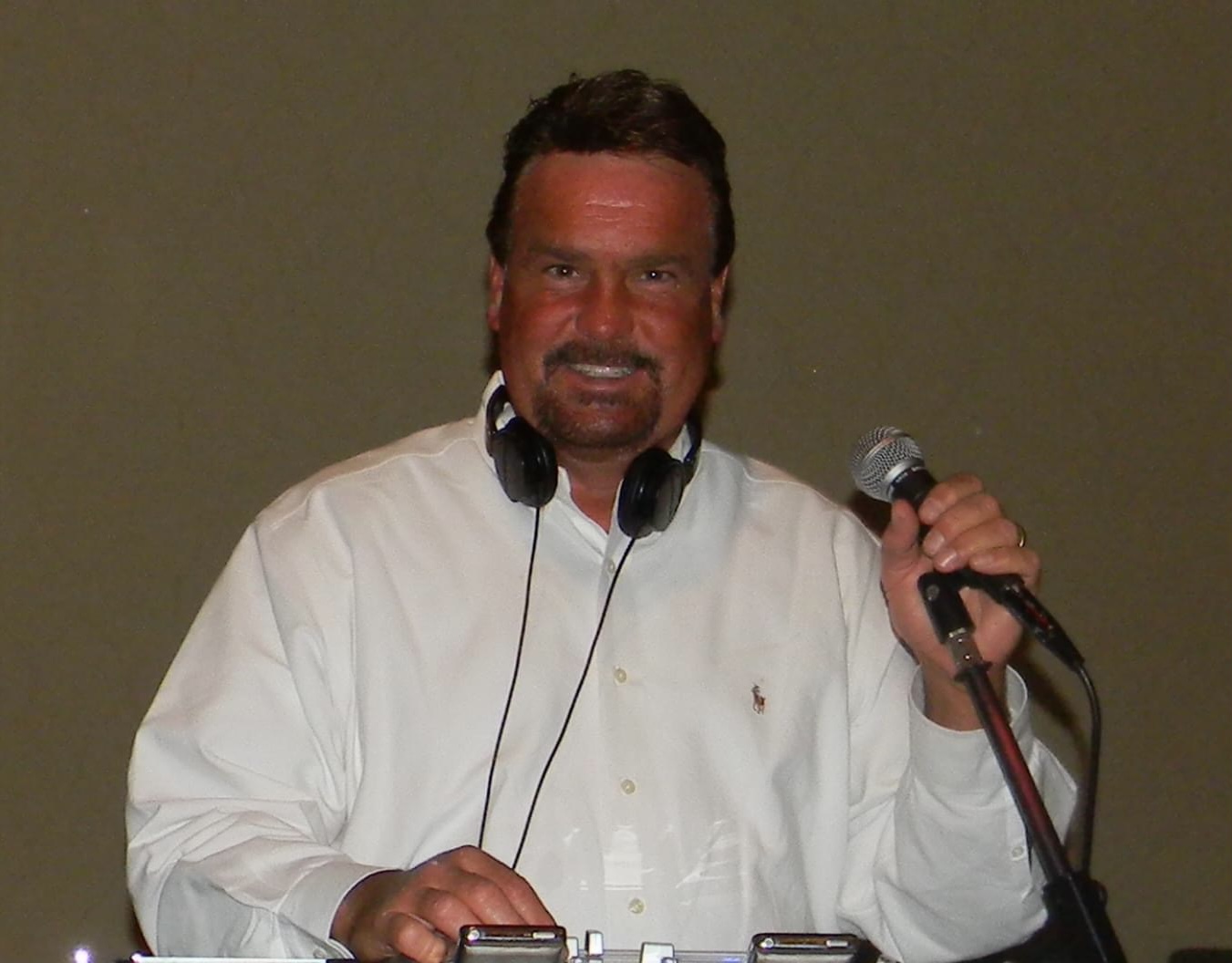 Man smiling while holding a microphone