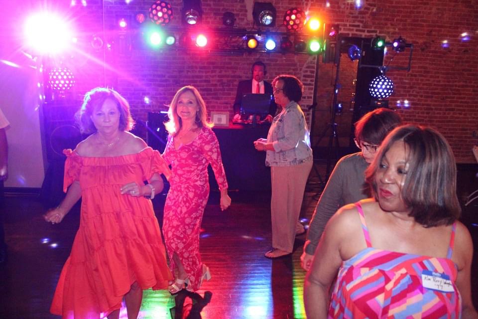 Group of women dancing with colorful lights background